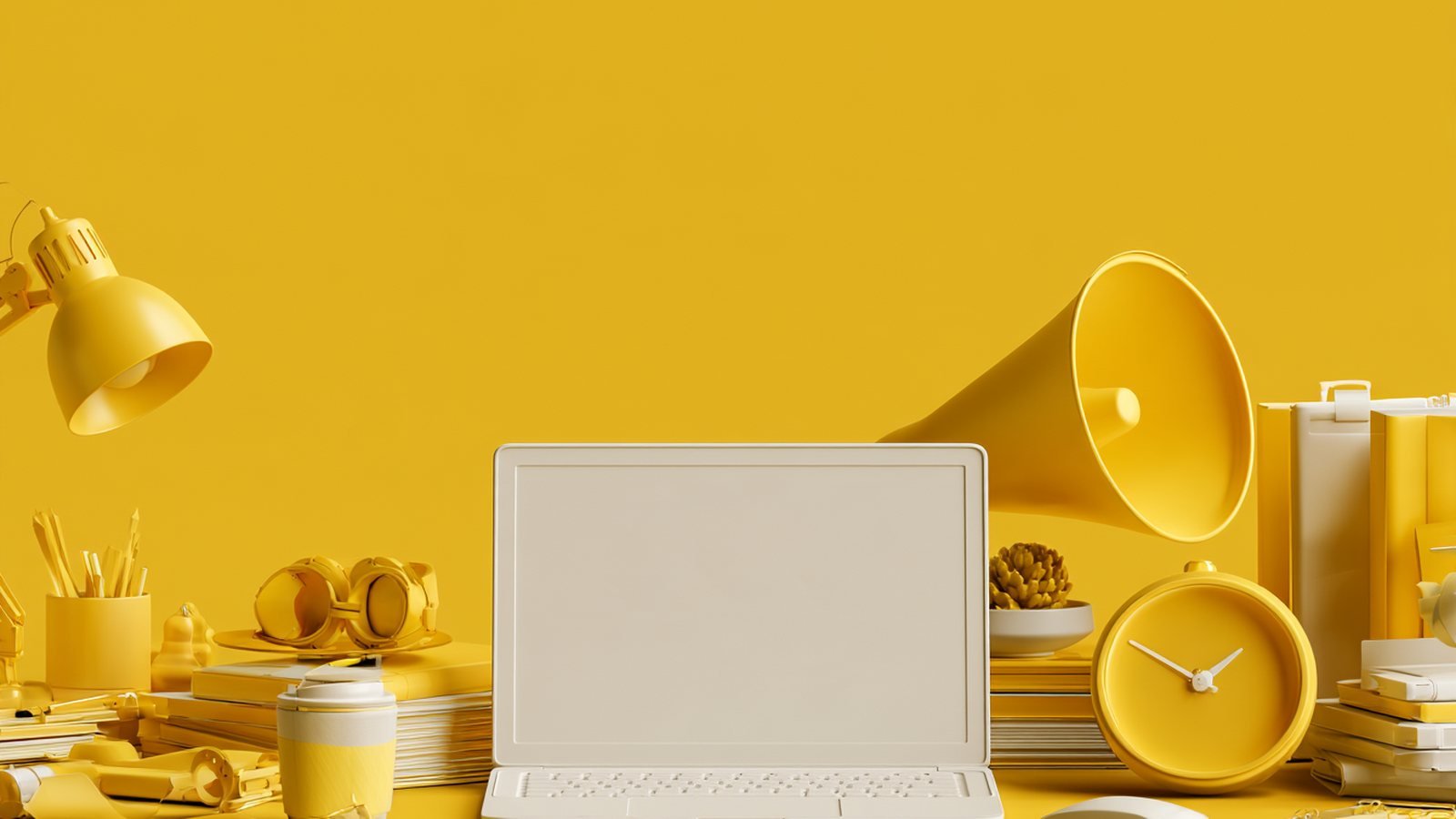 Escritorio de trabajo amarillo con un portátil abierto, un megáfono y material de oficina: lo que hay que mirar antes de poner el marketing de tu pyme en manos de una agencia